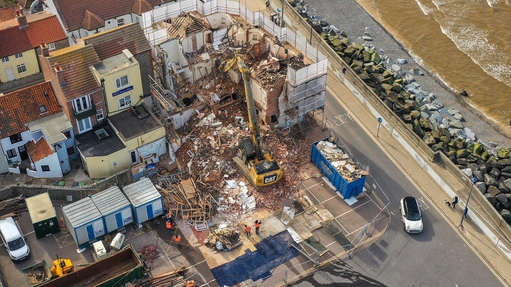 The hotel on Sheringham seafront is surrounded by scaffolding and being demolished by a digger