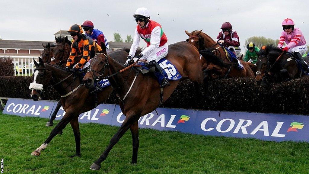 Horses jump a fence during the Scottish Grand National