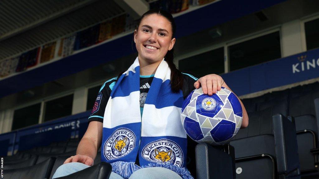 Emilia Pelgander is unveiled by Leciester City with a scarf round her neck and holding a club ball