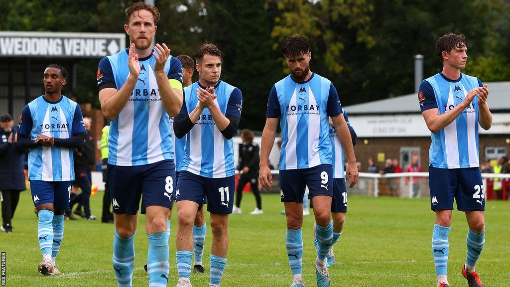 Disappointed Torquay players applaud their fans