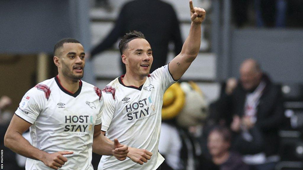 Kane Wilson holds his hand up in celebration after scoring for Derby against Bolton