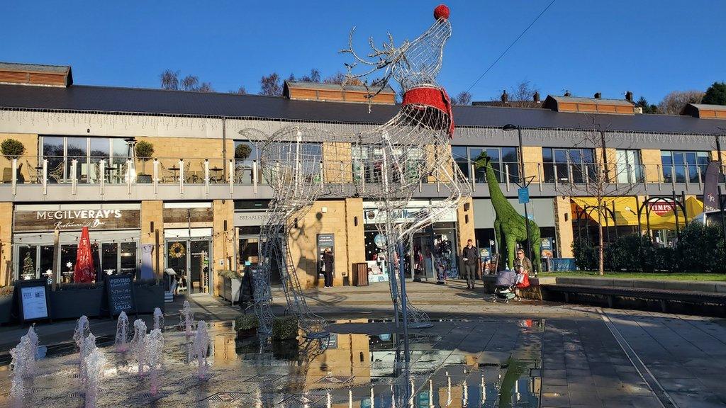 A shopping centre with a metal statue of a reindeer