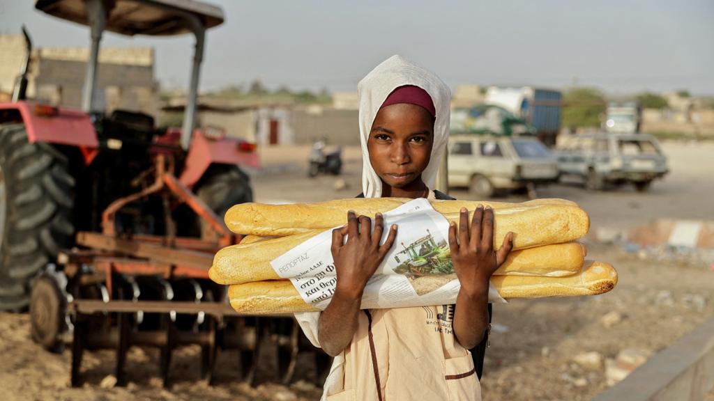 A child carries bread ahead of breaking fast during the Muslim holy month of Ramadan in Fass Boye, Senegal - 19 March 2024