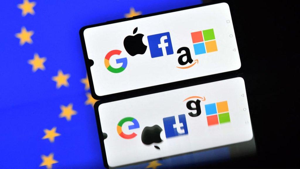 Smartphone displays Google, Apple, Facebook, Amazon and Microsoft logos against EU flag background