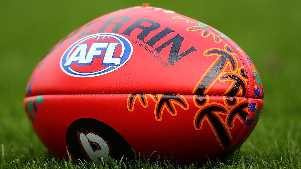 An AFL match ball with indigenous markings