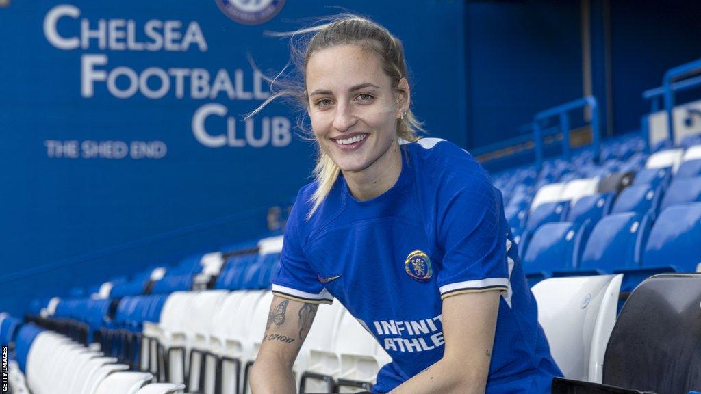 Nathalie Bjorn wearing a Chelsea shirt sat in the Shed End at Stamford Bridge