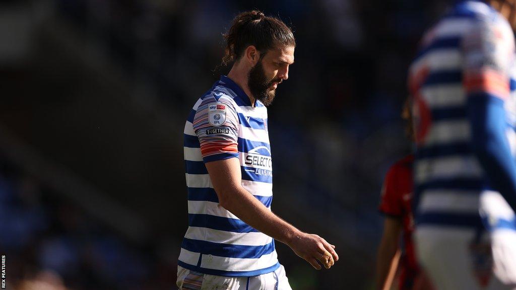 Former Reading striker Andy Carroll walks off the field, dejected, after another Championship loss in 2022-23.