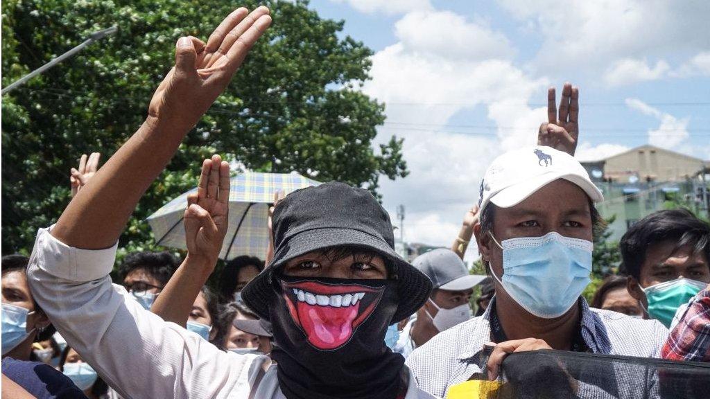 Protesters make the three-finger salute during a demonstration against the military coup in Yangon on May 12, 2021.