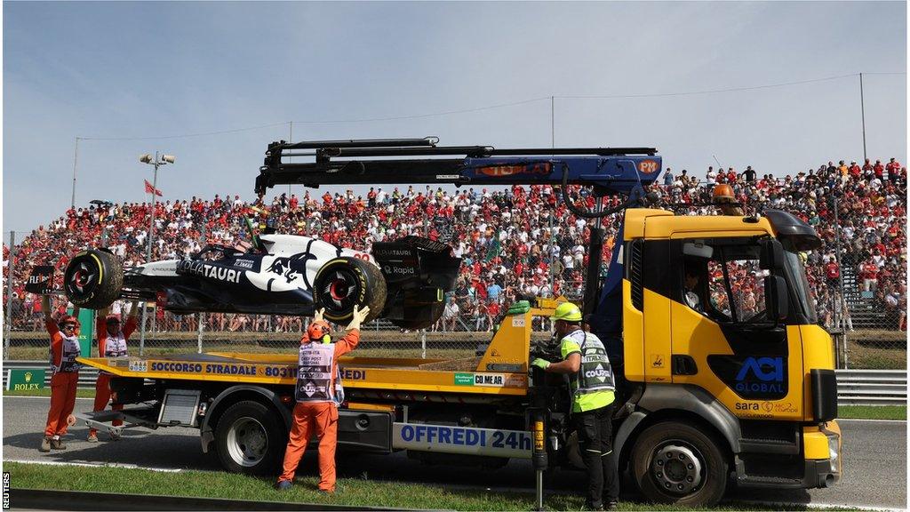 Yuki Tsunoda's Alpha Tauri is taken away after it breaks down on the formation lap