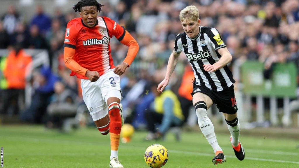 Anthony Gordon of Newcastle United is put under pressure by Gabriel Osho of Luton Town