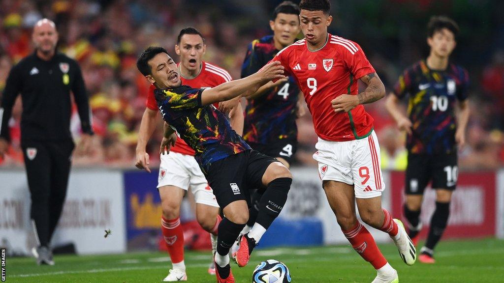 Brennan Johnson in action for Wales v South Korea (pushing over an opponent)