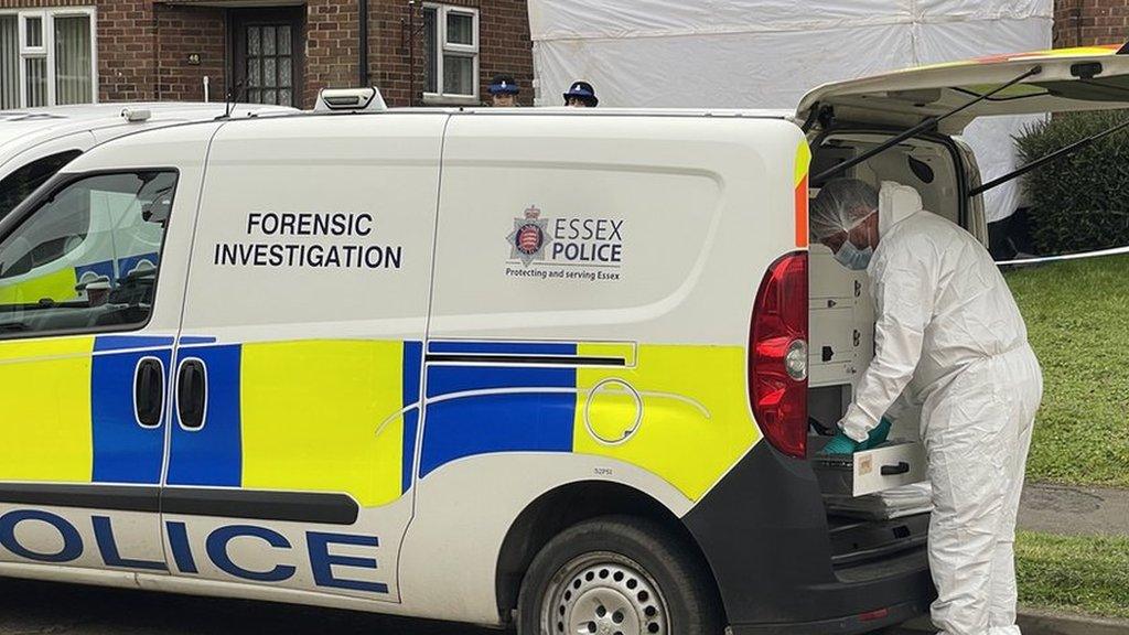 A forensic police officer outside a house