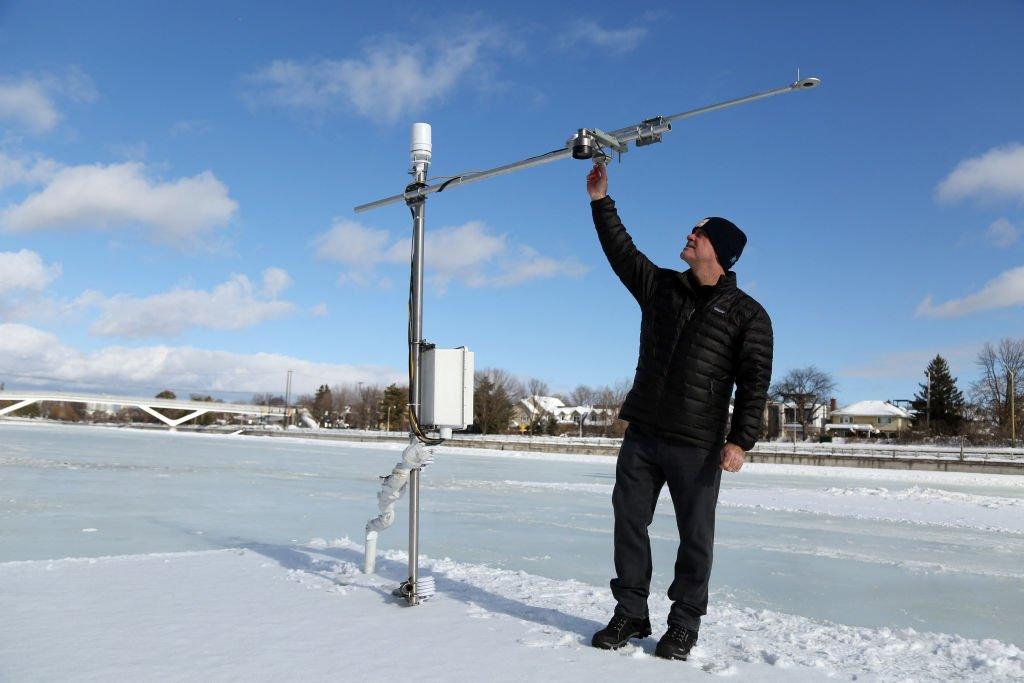 Carleton University professor Shawn Kenny adjusts weather equipment on the Rideau Canal