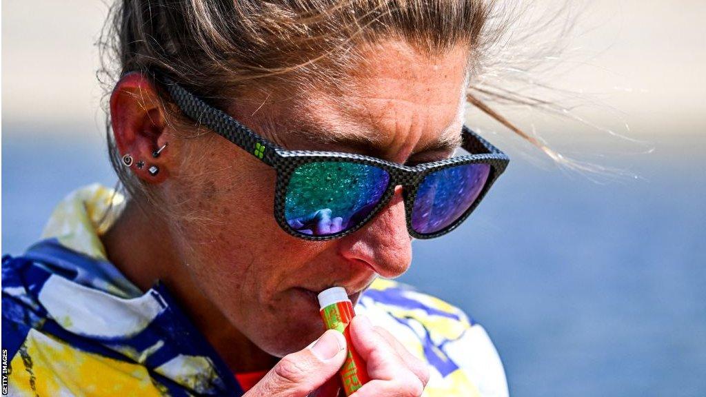 Courtney Dauwalter applies lip balm on a training run