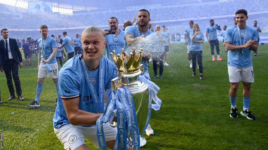 Manchester City striker Erling Haaland celebrates with the Premier League trophy