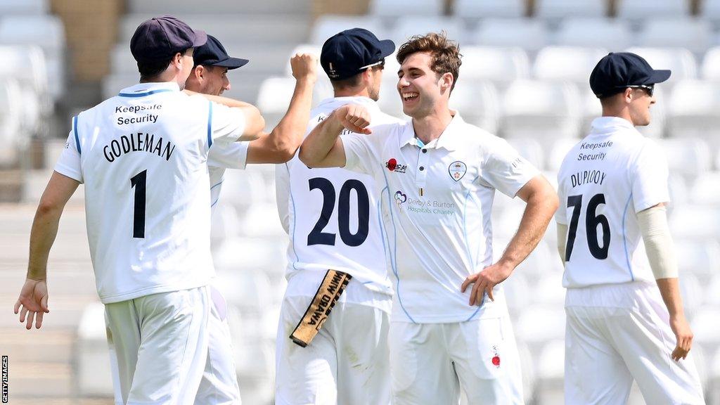 Michael Cohen (centre) celebrates with a team-mate