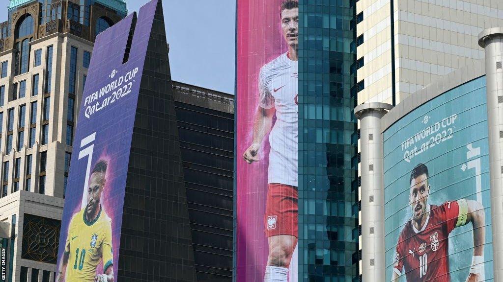 Giant pictures of Robert Lewandowski (centre), Brazil's Neymar (left) and Serbia's Dusan Tadic are on the side of buildings in Doha