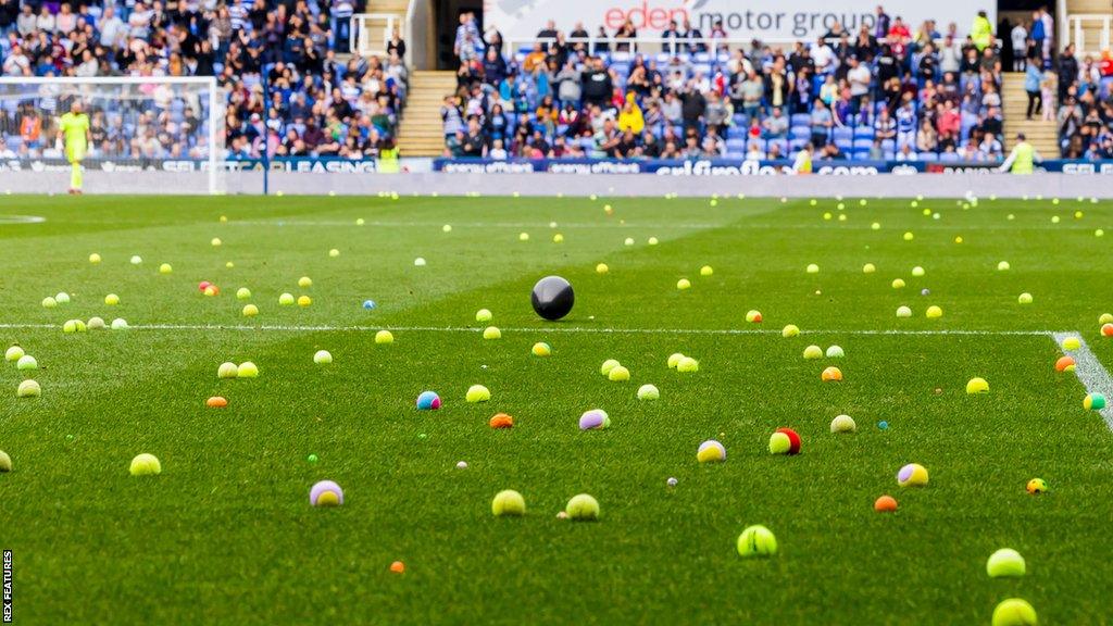 Tennis balls thrown onto the Reading pitch