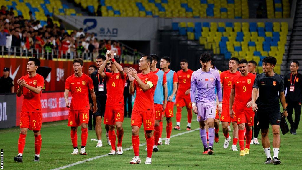 Chinese players walk off the pitch after losing 1-0 to Syria