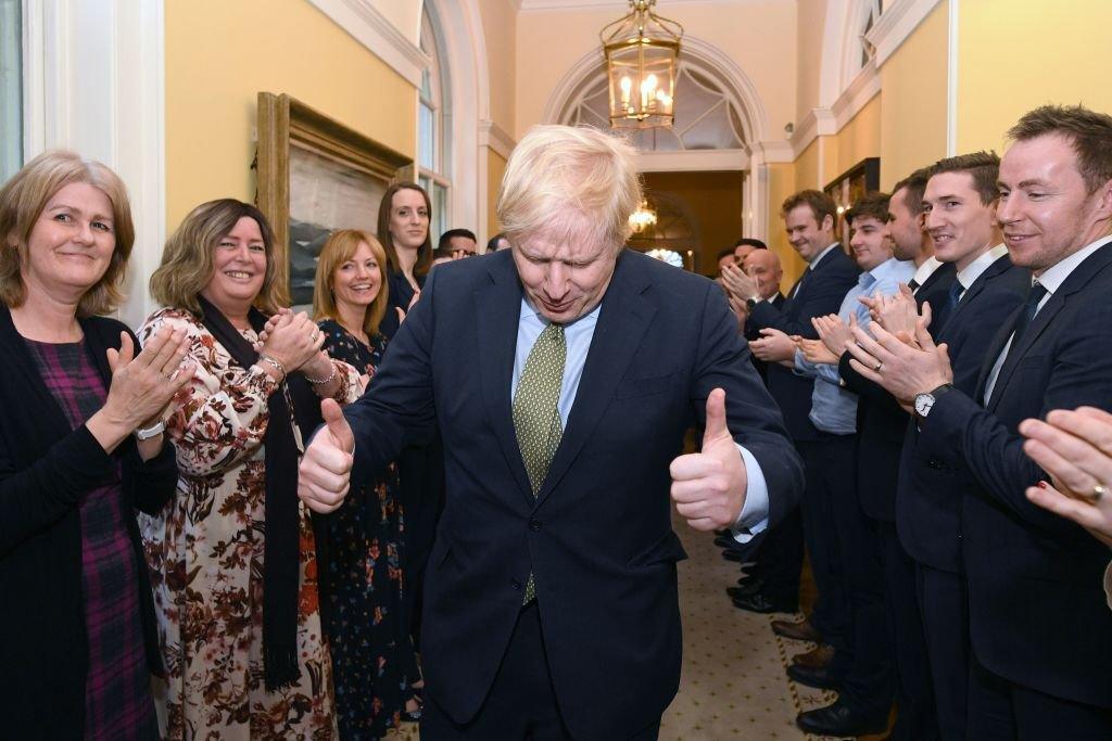 Britain's Prime Minister and Conservative Party leader Boris Johnson is greeted by staff as he arrives back at 10 Downing Street, 13 December 2019