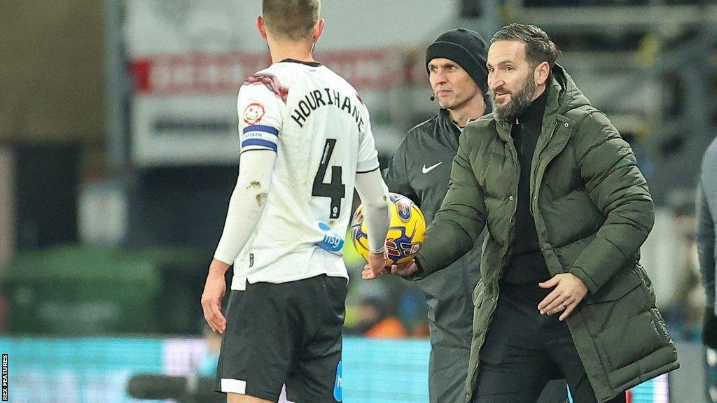 Burton boss Martin Paterson hands the ball to a Derby player