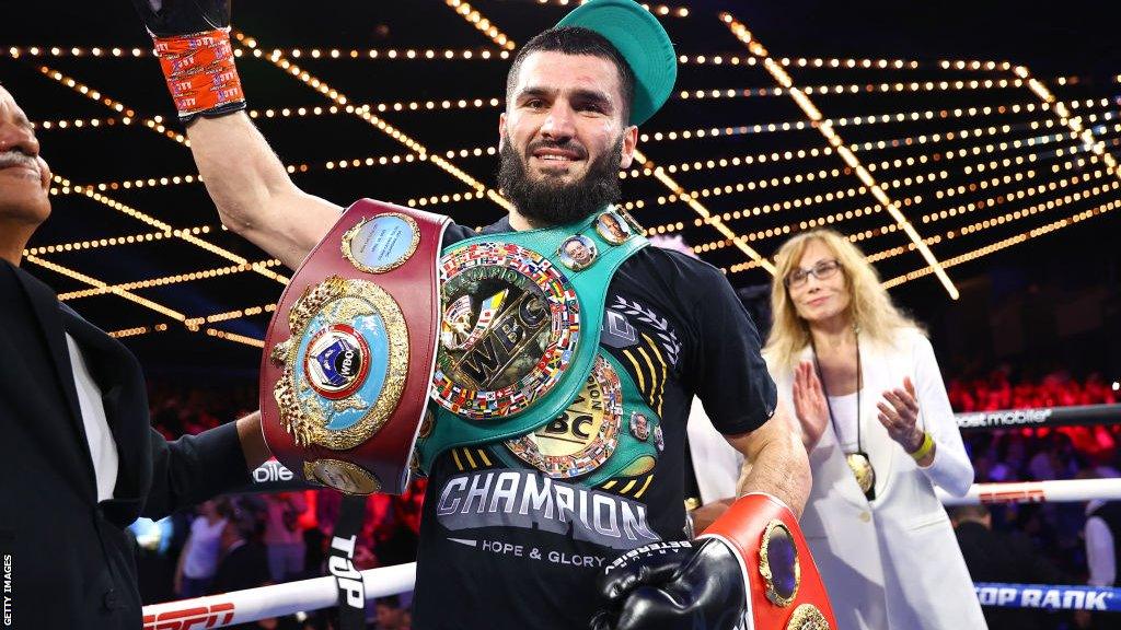 Artur Beterbiev celebrates with his three world titles