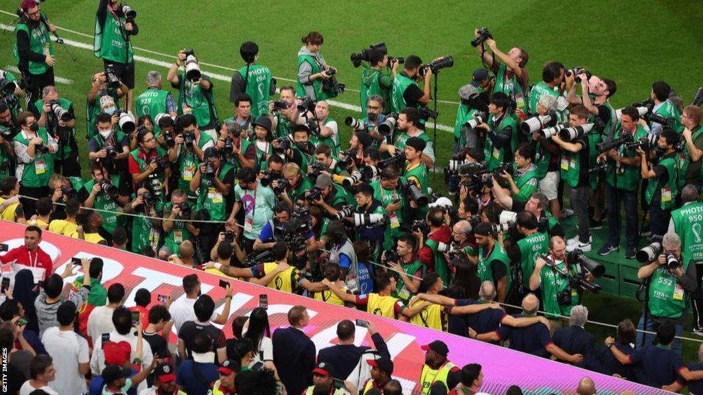 Photographers jostle for position to get a picture of Cristiano Ronaldo among Portugal's substitutes