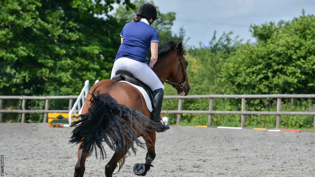 A woman riding a horse