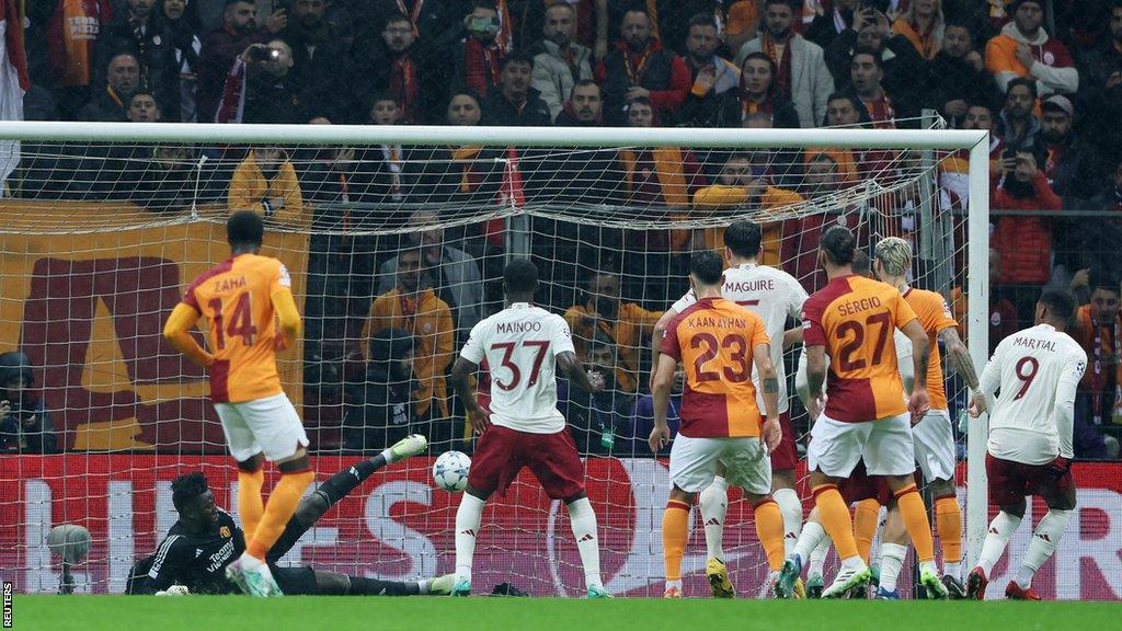 Players look on as the ball bounces beyond Andre Onana