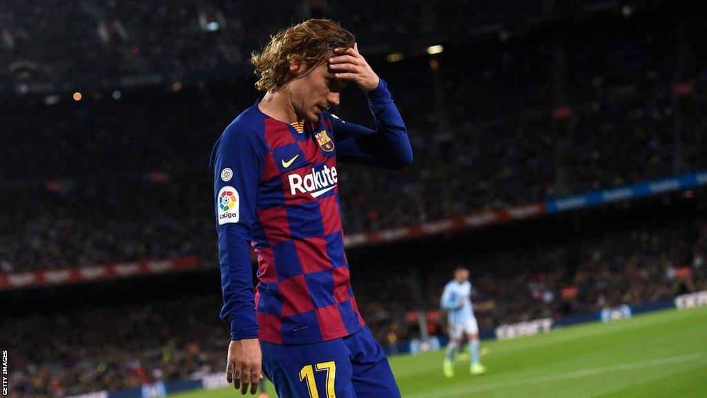 Griezmann holds his hand to his head as walks across the Nou Camp pitch