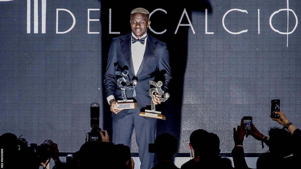 Victor Osimhen poses in front of photographers with his awards from the AIC