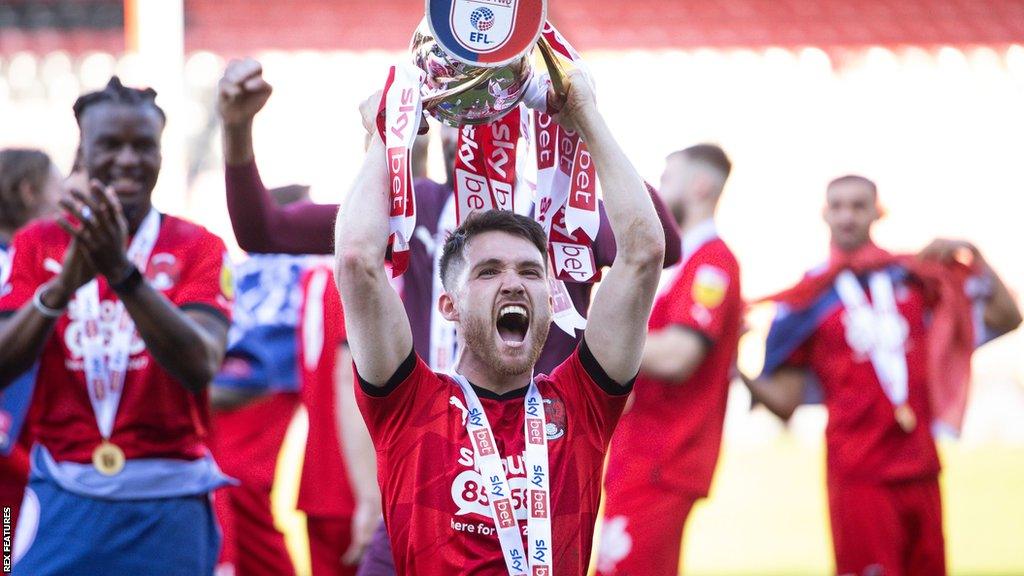 Leyton Orient forward Paul Smyth lifts the League Two trophy