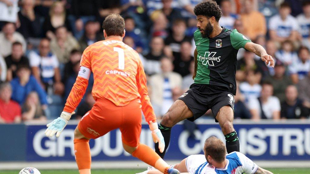 Ellis Simms of Coventry City has a shot blocked by Queens Park Rangers defender Steve Cook