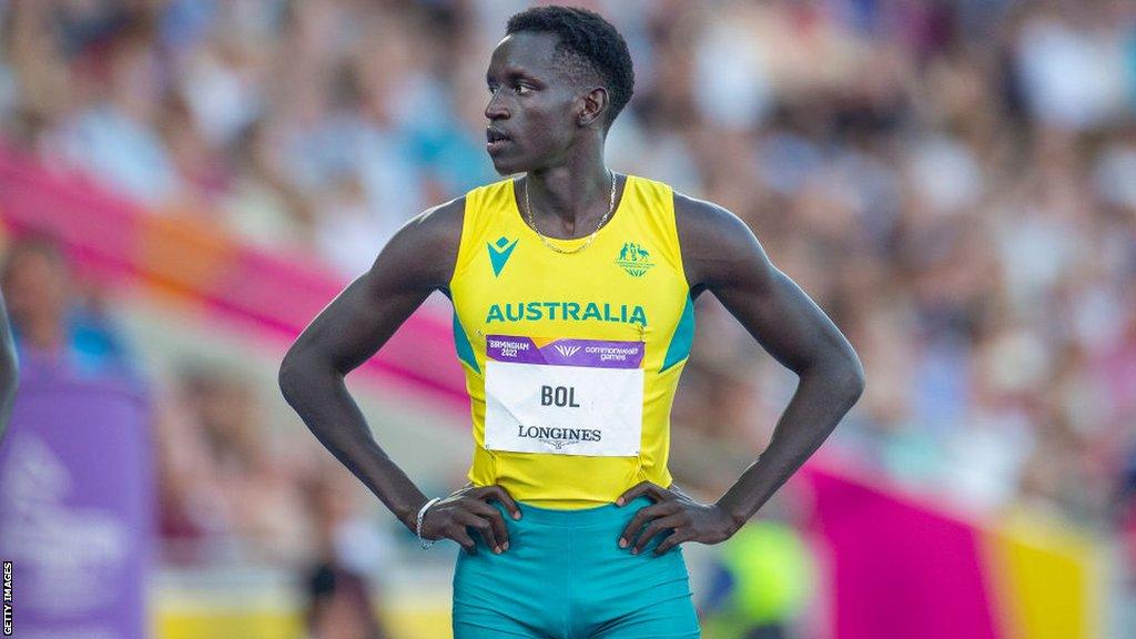 Peter Bol stands with his hands on his hips on the start line of the Commonwealth Games