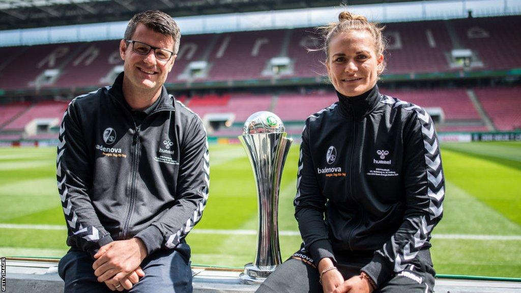 Jens Scheuer smiling with a trophy