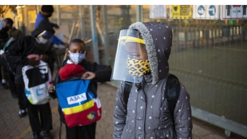 Children queue outside a school in South Africa