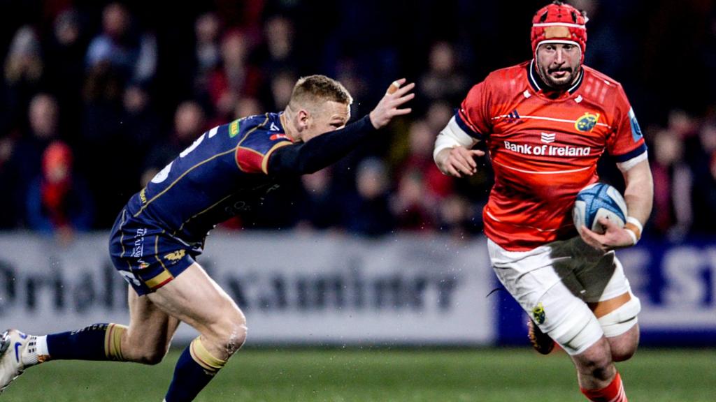 John Hodnett of Munster in action against Johnny McNicholl of Scarlets