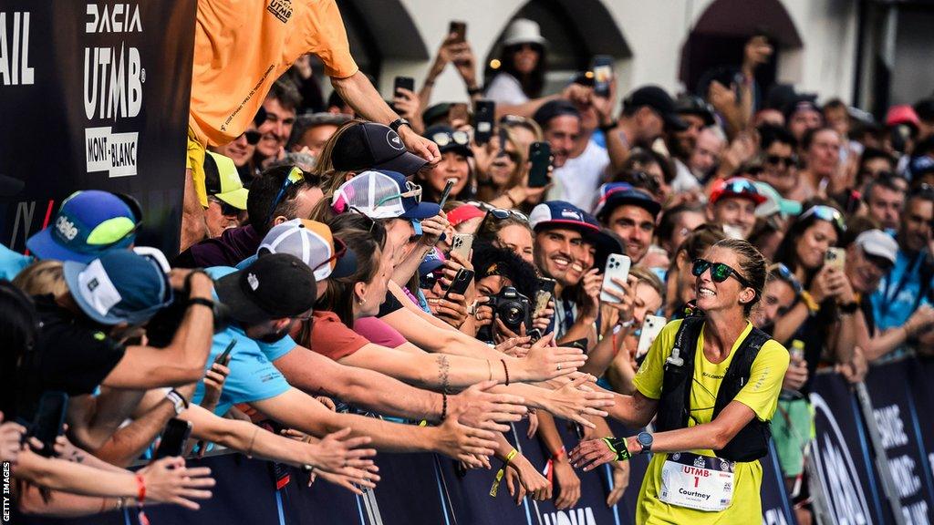 Courtney Dauwalter acknowledges the fans in Chamonix after winning UTMB for a third time