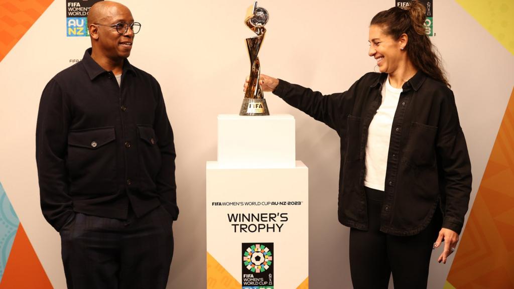 Ian Wright and Carli Lloyd pose with the FIFA Women's World Cup Trophy