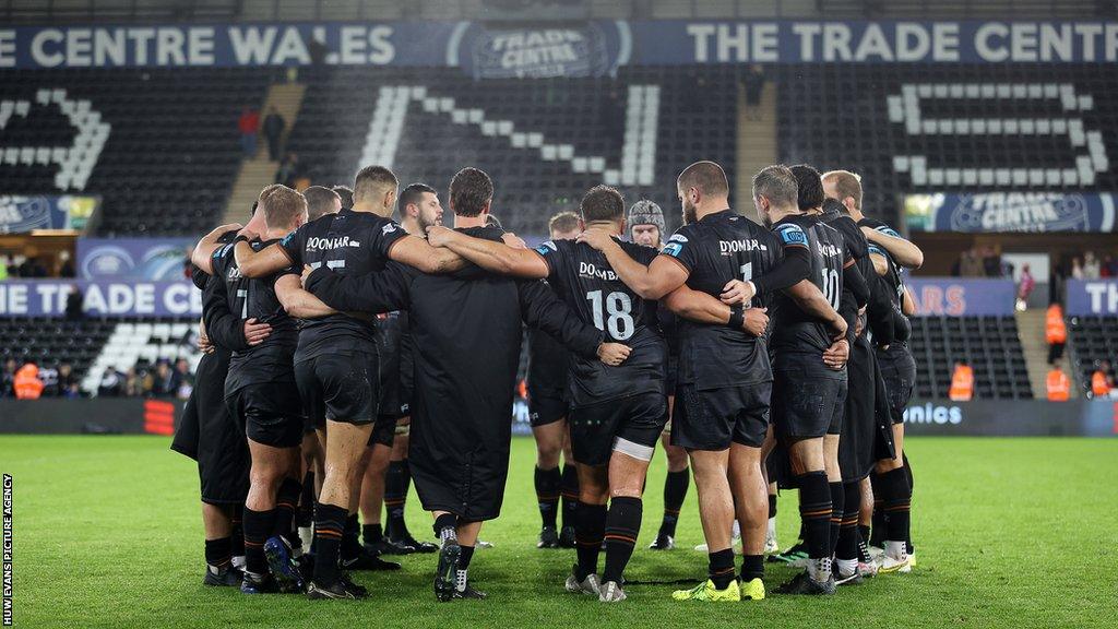 Ospreys players in a huddle.
