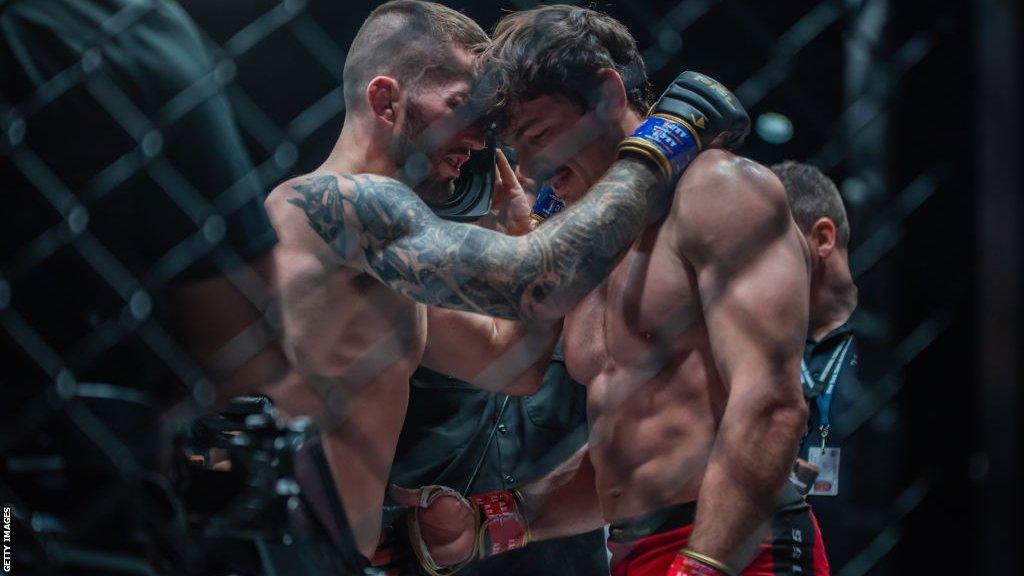 Stevie Ray hugs Olivier Aubin-Mercier in the cage