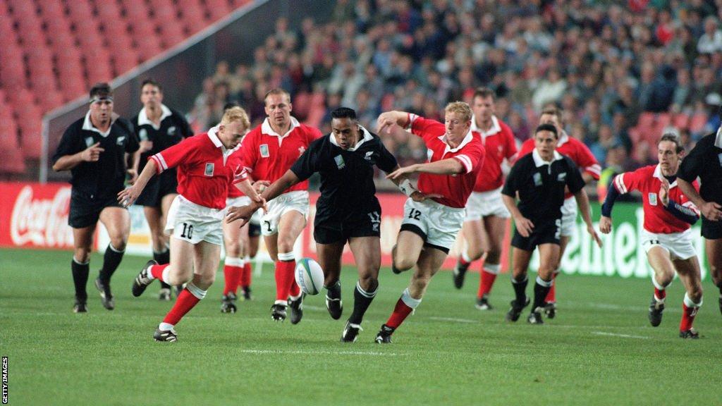 Jonah Lomu being chased by Gareth Thomas and Neil Jenkins during Wales' World Cup defeat against New Zealand