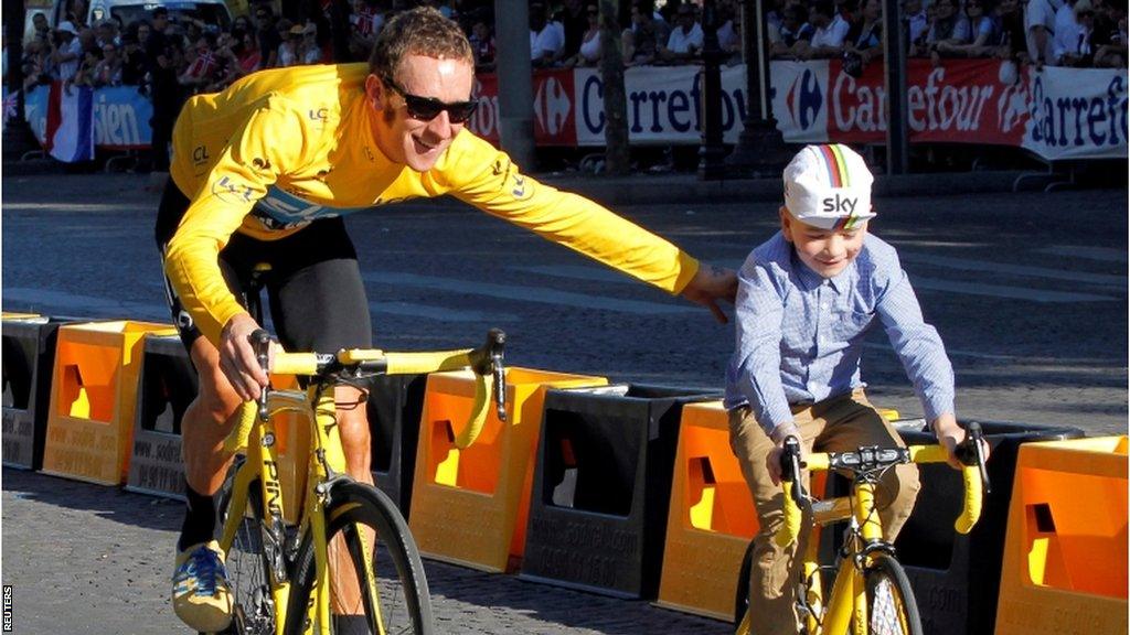 Bradley Wiggins rides with his son Ben on the Champs Elysees after winning the 99th Tour de France in 2012