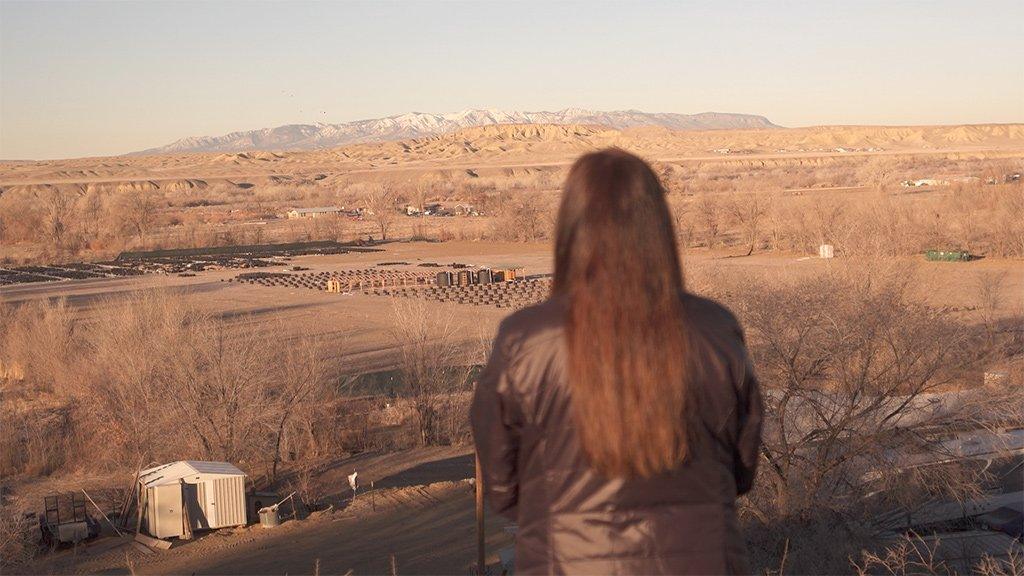 Bea Redfeather looks out at the top of a hill near her property in Shiprock, New Mexico