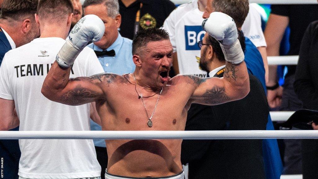 Oleksandr Usyk celebrates in the ring