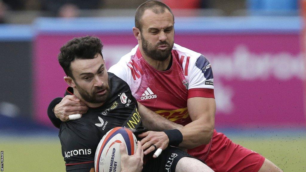 Dom Morris of Saracens (L) is tackled by Ross Chisholm of Harlequins