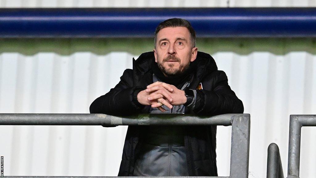 Northampton Town boss Jon Brady watching from the TV gantry against Oxford United