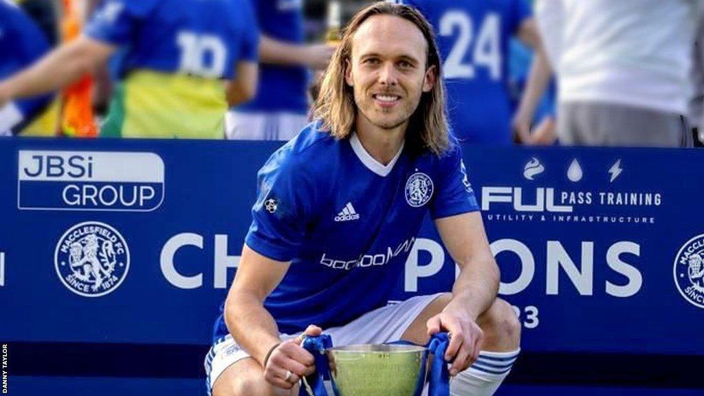 Tom Thorpe poses with a trophy after Macclesfield sealed promotion