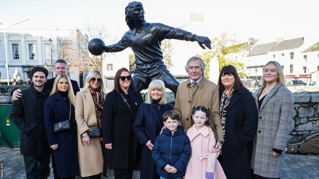 Pat Jennings and his family pose in front of the statue