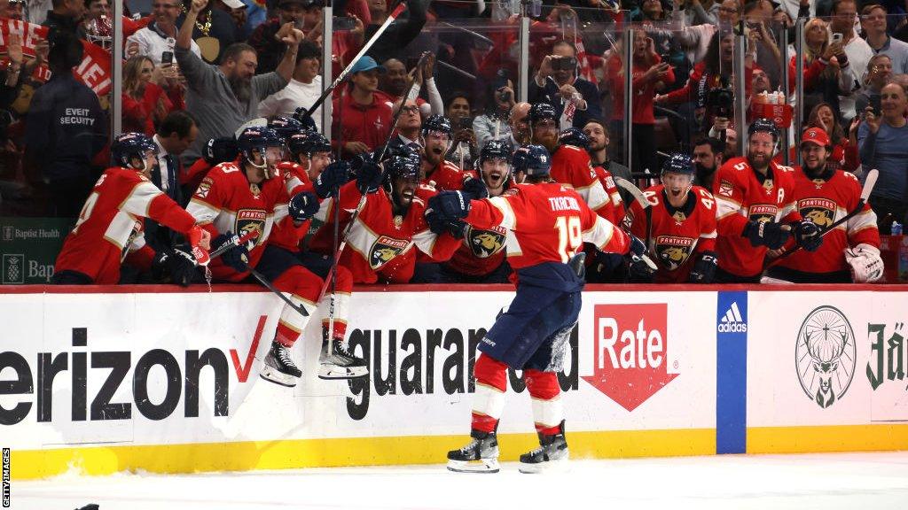 Matthew Tkachuk celebrates with his team-mates on the sidelines